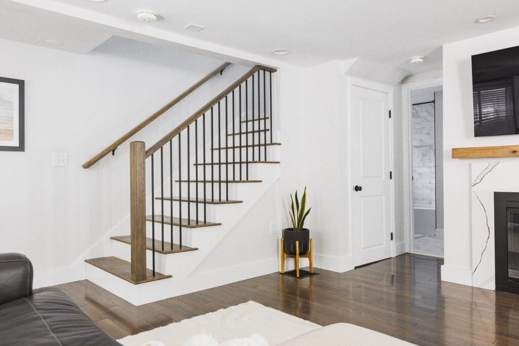 ¿How much cost to remodel a basement? The true cost of basement remodeling Cozy living room featuring a fireplace, couch, and TV, showcasing River City Construction's stunning basement renovation.