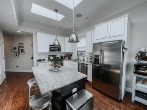 A modern kitchen featuring stainless steel appliances and a skylight, showcasing high-end remodeling by River City Somerville Construction.